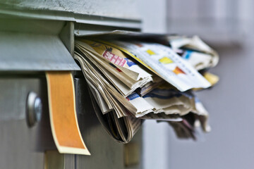 Mailbox overflowing with newspapers
