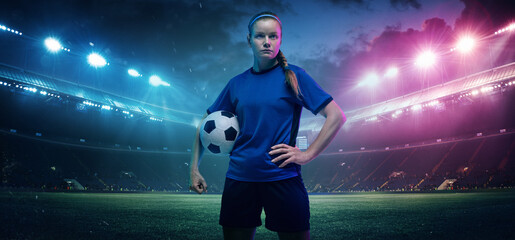 Holding ball, self-confidence. Football or soccer player on full stadium and flashlights...