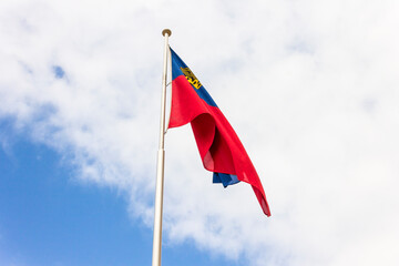 Vaduz, Liechtenstein. Flag of the Principality of Liechtenstein waving in the streets of the capital city