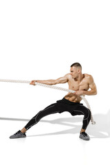 Fototapeta na wymiar Tug of war. Stylish young male athlete practicing on white studio background, portrait with shadows. Sportive fit model in works out in motion and action. Body building, healthy lifestyle, style