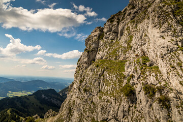 Hiking from the mountain station to the top of the mountain called Wendelstein in Bavaria, Germany at a cloudy day in summer. View along the rocks.