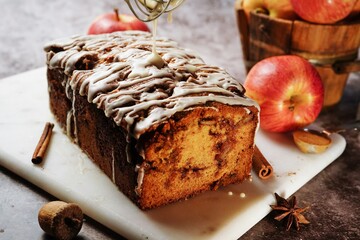 Homemade Apple Fritter Bread drizzled with white glaze on fall autumn background, selective focus
