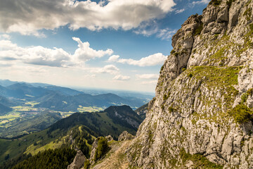 Hiking from the mountain station to the top of the mountain called Wendelstein in Bavaria, Germany at a cloudy day in summer. View along the rocks.