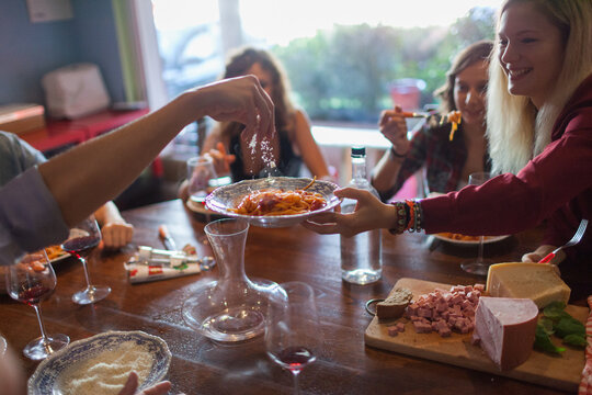 Serving Italian Spaghetti Pasta During a Meal With Friends
