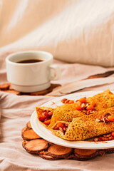 Gluten-free keto Crepes filled with pear, walnut and cinnamon in the oven with sea buckthorns on top. Autumn vegetarian breakfast or healthy dessert concept