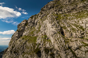 Hiking from the mountain station to the top of the mountain called Wendelstein in Bavaria, Germany at a cloudy day in summer. View along the rocks.