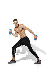 Weights. Stylish young male athlete practicing on white studio background, portrait with shadows. Sportive fit model in works out in motion and action. Body building, healthy lifestyle, style concept.