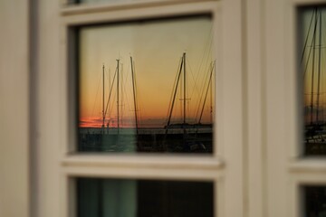 zonsondergang in de jachthaven, weerspiegeld in het raam