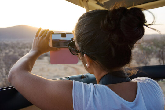Young woman photographing in Africa with your mobile