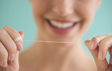 Close-up of woman holding dental floss