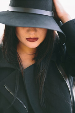 closeup of young woman with black hat and red-wine color lips