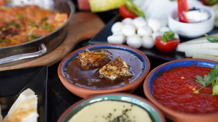 Turkish breakfast table. Close up shot.  Honey, cheese tomato,butter, hot spicy tomato dip and  	eggs scrambled with tomatoes and green pepper. Close up shot.