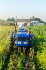A farmer on a tractor drives across the farm field and harvests. Farming, agriculture. Improving...