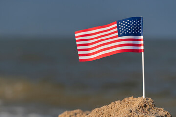 Flag of USA on the beach. National flag of America, sea background.