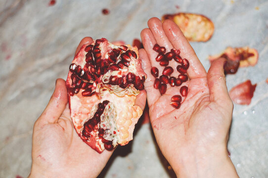 Girl holding a broached pomegranate