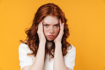 Image of ginger unhappy girl with headache posing on camera