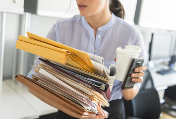 Business woman holding stack of documents in office