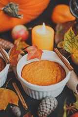 Homemade pumpkin souffle. On an autumn background with maple leaves, candles, apples, pine cones, pumpkins, cinnamon and star anise. Thanksgiving Day. Autumn composition still life. Autumn postcard.