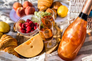 Close up image of tasty food in picnic, sunny colors, cheese fruits bread and champagne, testy breakfast outdoor.