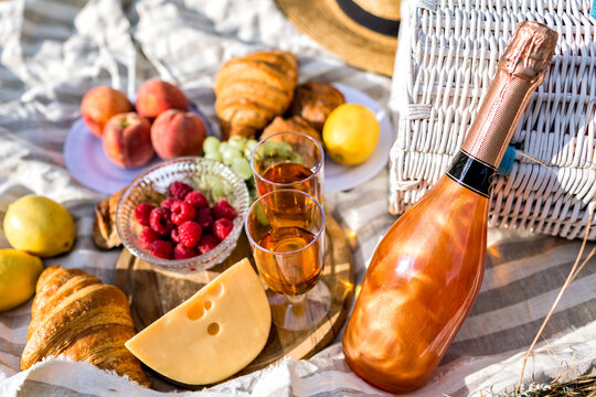 Close up image of tasty food in picnic, sunny colors, cheese fruits bread and champagne, testy breakfast outdoor.