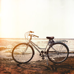 Naklejka na ściany i meble Urban white retro bike with brown seat on the background of the bay. Rear light. Life style.