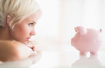Woman staring at piggy bank