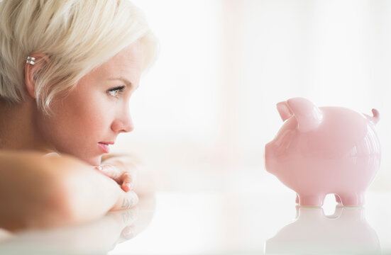 Woman Staring At Piggy Bank