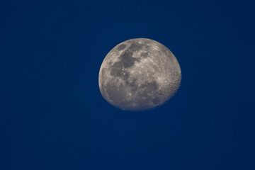 The moon is not full. See the details of the pit before the darkness. The surrounding sky is blue.