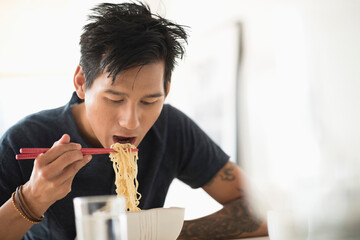 Man eating noodles with chopsticks