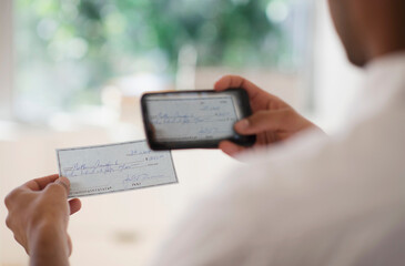 Man taking photo of banking check with cell phone