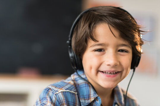 Portrait of smiling schoolboy (6-7) in headphones