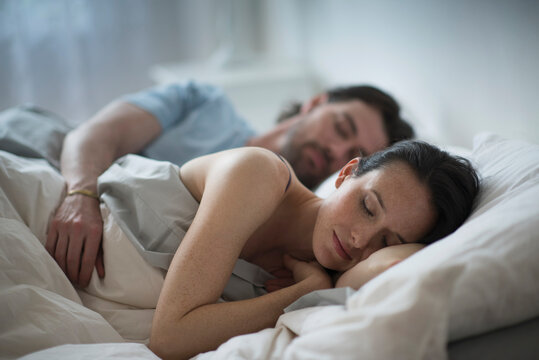 Couple sleeping together in bed at night