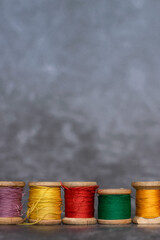 Different colorful cotton mill on grey background