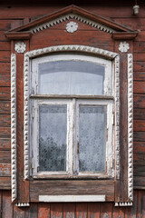 Gingerbread wood trims. Window decoration of an old wooden brown house