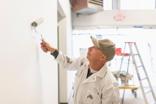 Manual worker painting wall