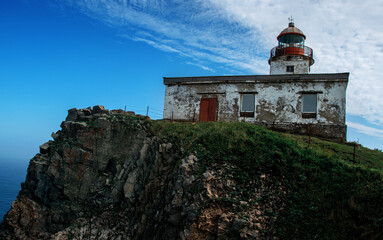 Fototapeta premium Old lighthouse located on the Pacific ocean. Beautiful scenery on a Sunny day.