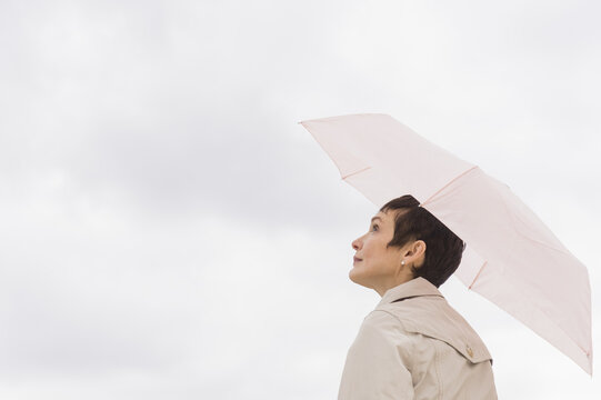 Woman wearing raincoat and holding umbrella