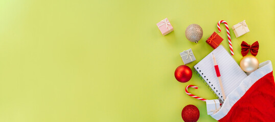 Medicine christmas new year concept banner during coronavirus covid-19 time. Top view of medical pills, disposable protective face mask, gift box, stethoscope in santa hat on red background.