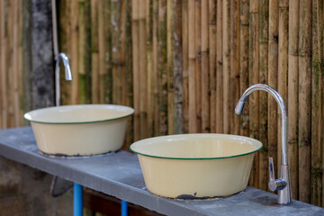 the sink is made with zinc basin with stainless steel water tap  and a wall made of bamboo