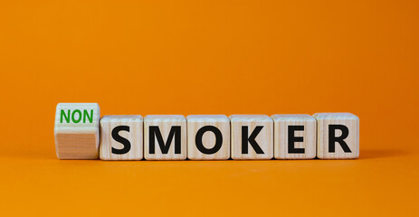 Turned a cube and changed the expression 'smoker' to 'non smoker'. Beautiful orange background. Stop smoking concept. Copy space.