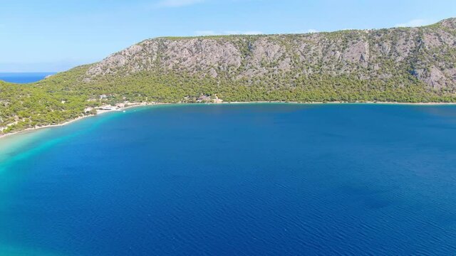 Aerial view of turquoise clear water and sandy beach of Ireon or Limni Vouliagmeni Lake in Peloponnese, Greece 