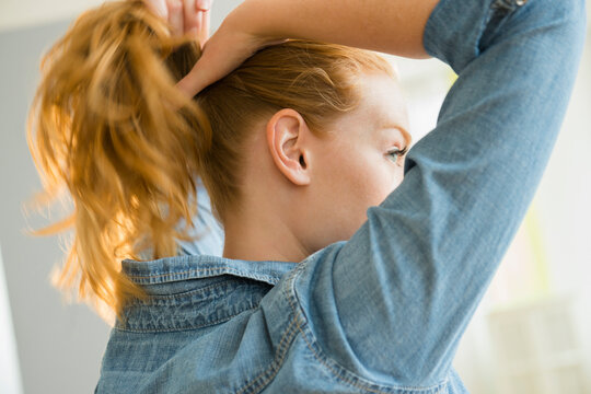 Young woman tying hair