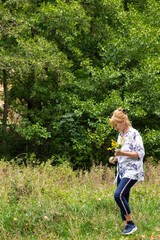 Senior woman holding wildflowers. Outdoor healthy lifestyle