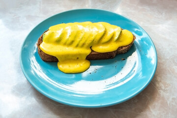 Delicious Avocado toast coveded with golandez sauce