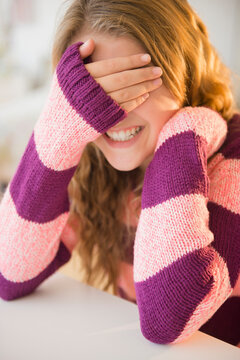 Girl (12-13) grinning and covering eyes