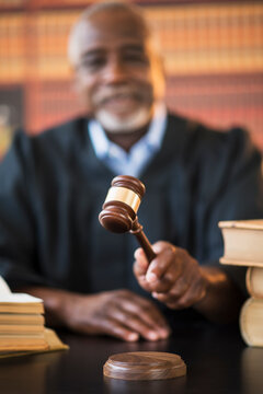 Judge holding gavel in courtroom