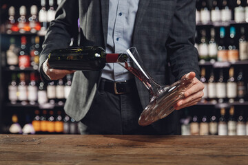 Sommelier man pours red wine into decanter for aeration of taste and aroma