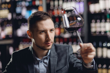 Sommeliers male hold glass red wine tasting degustation card