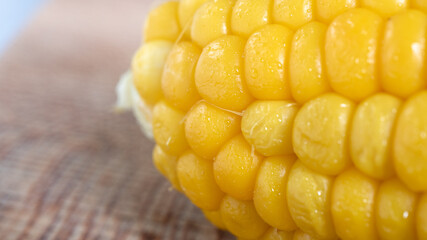 Delicious corn on the cob captured in an extreme close up. The brightly glowing yellow kernels form a recognizable pattern. The cob was lightly boiled and seasoned with salt.
