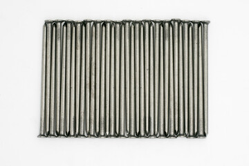Fototapeta Metal nails neatly stacked on a white background obraz